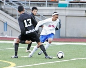 Kent-Meridian’s Fermin Samario splits the defense of Kentlake midfielders Alexis Ng and Roberto Morales (No. 13) during Friday night’s game at French Field. Kentlake went on to win the game