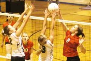 Kent-Meridian’s McKaley Brewer (right) tries to split the defense of Kentwood’s Elle Mortensen (left) and Stephanie Shumaker (middle). Brewer