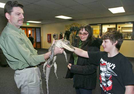 Reptile Man Scott Petersen holds up his alligator Lucy for Crestwood teacher Rachel Moore and student Bobby Dixon to pet after their school assembly Dec. 2.