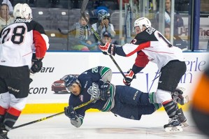 The Thunderbirds’ Keegan Kolesar tumbles to the ice from a Cougars check