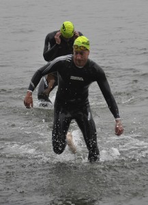 Swimmers exit the water on their way to the bike leg of the Lake Meridian Triathlon last Saturday.