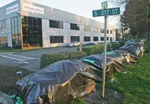 Office Depot facilities in Kent’s Cascade Commerce Park on West Valley Highway are shown with a sandbag wall to protect against flooding.  The state Legislature is working on measures to provide more flood insurance for businesses in the Green River Valley.