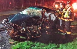 Firefighters check out a Honda Civic involved in a collision with another car on Monday night in Kent. The woman driver of the Civic died at the scene and two of her passengers were injured.
