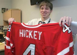 Kentlake student Matt Swanson holds up a Team Canada jersey for T-Bird Thomas Hickey Jan. 9