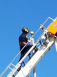 Tall task: A Kent firefighter repairs the flapole line at the Harrison House.
