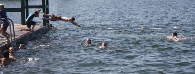 Swimmers jump into Lake Meridian this week in Kent to beat the heat.
