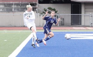 Kentwood’s Reiney Meyers slips a shot past Auburn Riverside defender Katie Baber during last week’s game.