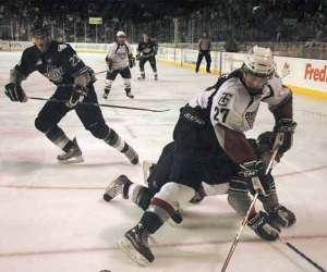 Americans’ defender Brett Plouffe (27) tries to regain control of the puck after a crash Sunday with a Thunderbird player
