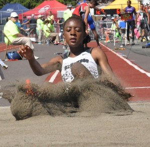Kentwood's Brittany Woke leaps a personal-best 18-0¼ to capture the 4A state long jump title Friday.