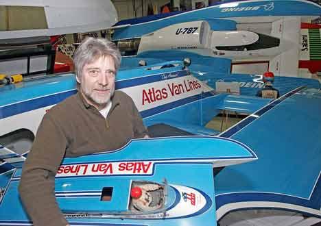 Hydroplane Museum volunteer Don Mock sits on the 1982 Atlas Van Lines boat as he holds his favorite replica boat at the Hydroplane Museum in Kent Feb. 4.