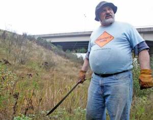 Doug Hill points out some of the invasive plants Tuesday that grow on the hill of the South 277th Street overpass just above the Green River Road. Hill plans to become a Green Kent steward to oversee the area for the city.