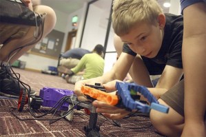 Ryan Deboer makes an adjustment to his team’s robot at the Robot Garage event at the Kent Library on Tuesday.