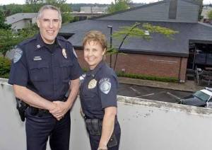 Kent Police Capt. Ron and Lt. Lisa Price pose atop the Centennial Building Parking Garage with Kent Police Station behind them May 21. They will be leaving Kent for Montana