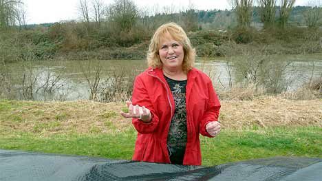 Kent resident Diane DeMeerleer stands along the Green River levee near her condominium at The Lakes. Kent city officials are hiring private forms to certify the levees for safety and to help lower insurance rates.