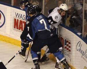 Thunderbirds Mitch Elliot crushes Blades' Darren Dietz into the boards as the fight for possession