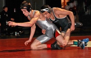 Kentwood's Ruben Navejas (right) explodes off the whistle in the 119-pound bout against Kentlake's Jeff Harjehausen. Navejas won the match 12-0 to improve to 22-0 this season.
