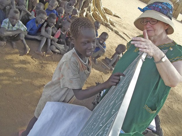 Coleen Bertino teaches the alphabet in Malwal’s outdoor “school.”   Kent Lutheran provided a portable library