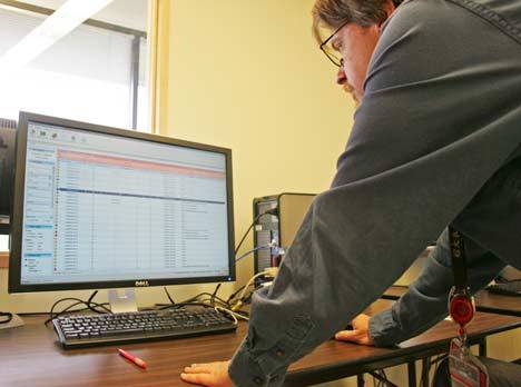 Tom Oxley with King County Elections looks through a list of ballots that have been electronically scanned and filtered to only include the Kent School District board member race Sept. 9.