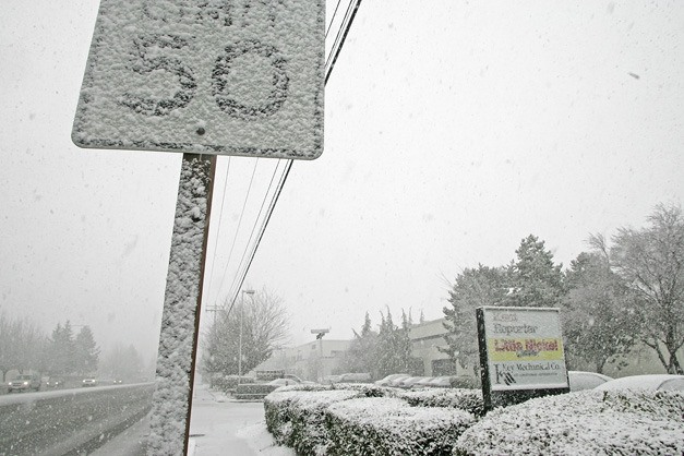 02/23/11 Snow is building up fast on West Valley Highway and the signs in front of the Kent Reporter offices Feb. 23.