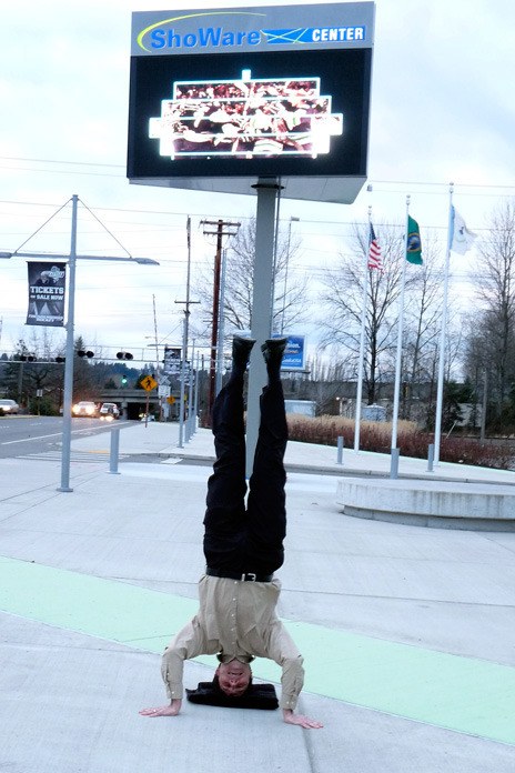 Kent City Councilman Dennis Higgins stands on his head to help promote the ShoWare Center's Marquee Tickets Contest.