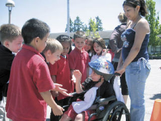 Meadow Ridge Elementary students crowd around to give first-grader Anthony Rupan fives at a Walk-a-thon event to raise money for the 7-year-old student. Rupan has been fighting a brain tumor for the last two months