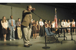 Mill Creek Middle School teacher James Frame acknowledges the work of his students at their first-ever mock Congressional hearings June 9 at the school.
