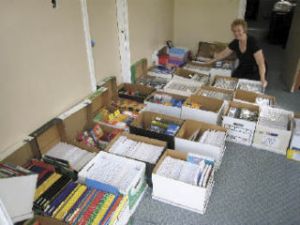 Kent Rotary member Kay Cook poses with some of the 30 boxes of school supplies bought by Rotary members and delivered to the Kent and Neely-O’Brien elementary schools.