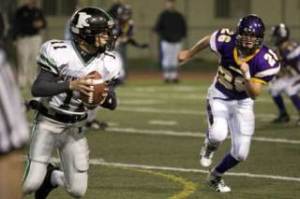 Kentlake’s Luke Angevine rolls out of the pocket in search of an open receiver Saturday against Issaquah. The Conks lost the game in the state opener