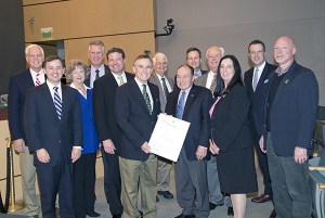 Former Green River College president Rich Rutkowski and King County Councilmember Pete von Reichbauer hold the recognition from the County Council marking Green River's 50th anniversary. They are joined by Green River President Eileen Ely