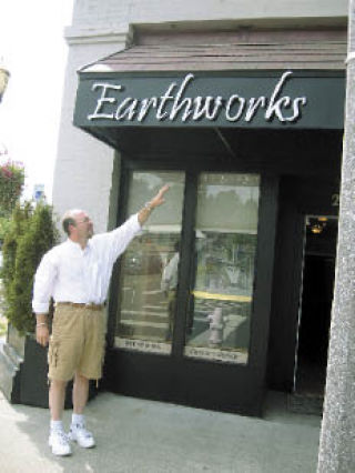 Steve Saint Louis points to the new awning at his shop. The awning was purchased in part with matching grant money received from the Kent Downtown Partnership.