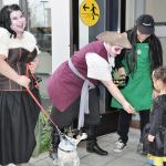 From left, Mary Dempsey, Fluke the dog, Katie Mathews and Valerie Phanissay hand out candy to trick-or-treaters at Green River College&rsquo;s campus at Kent Station on Monday evening. HEIDI SANDERS, KENT REPORTER