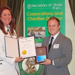 Secretary of State Kim Wyman congratulates Jarrett Tomalin, community relations supervisor at Sleep Train, during a recent ceremony. The Kent-based mattress company earned the Corporations for Communities Award for its work in the community. COURTESY PHOTO