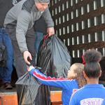 Kent Firefighter Rod Carlson unloads bags of donated toys and gifts from a truck to an assembly line of volunteers prior to distribution at Kent Lutheran Church on Dec. 22. MARK KLAAS, Kent Reporter