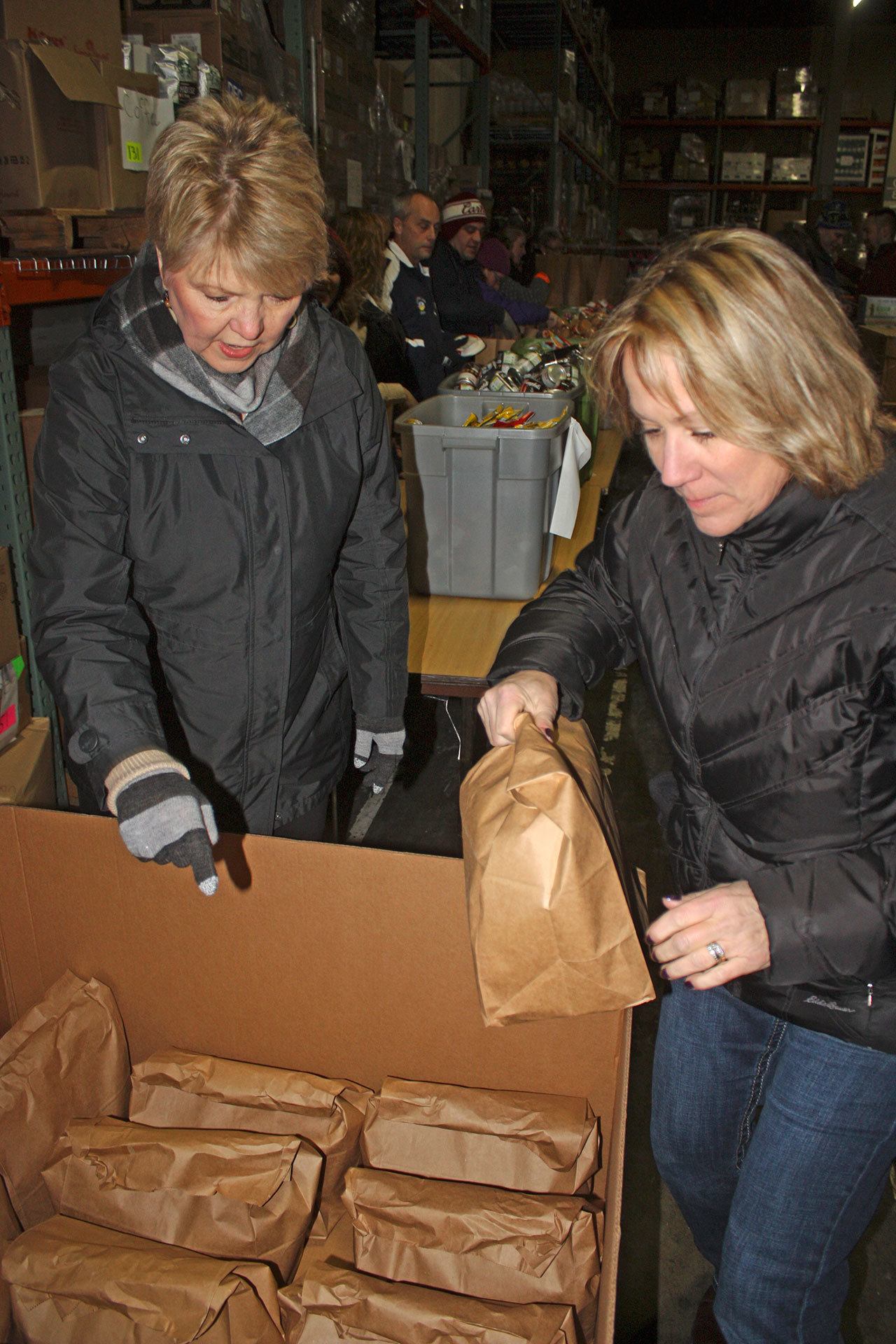 Volunteers Shelly Brown, right, and Loretta Shindler organize food-filled bags during the Backpack Buddy Program&rsquo;s packing party at Seattle&rsquo;s Union Gospel Mission warehouse in Kent on Jan. 4. MARK KLAAS, Kent Reporter
