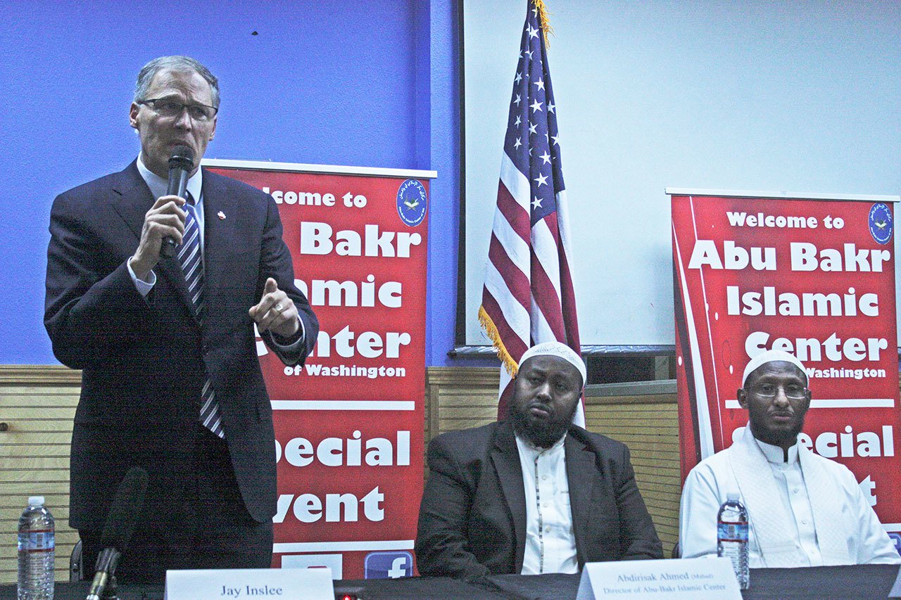 Gov. Jay Inslee speaks to a gathering at the Abu-Bakr Islamic Center in Tukwila on Friday. Abdirisak Ahmed (Mahad), the center&rsquo;s director, middle, and Shiekh Ahmed Nur, Iman of the center, right, listen. MARK KLAAS, Kent Reporter