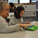 Jackie DeCamp, a paraeducator in the Adaptive Support Center at Cedar Heights Middle School, helps Melissa use her iPad to communicate. HEIDI SANDERS, Kent Reporter