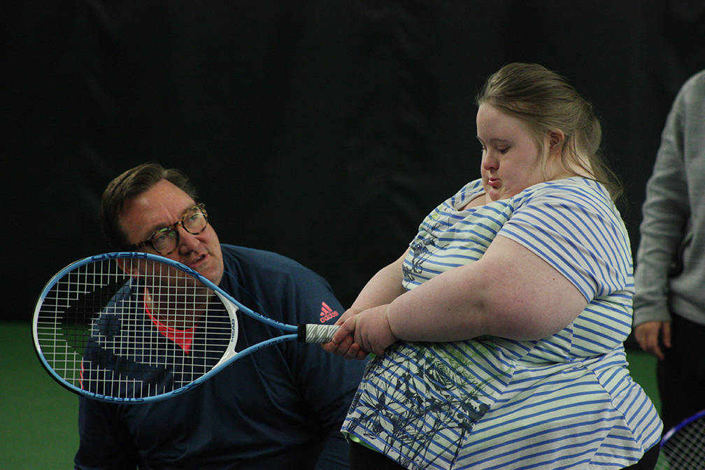 Vince Schmidt, tennis pro and co-founder of the Jensen-Schmidt Tennis Academy for Individuals with Down Syndrome, works with a player during camp. MARK KLAAS, Kent Reporter