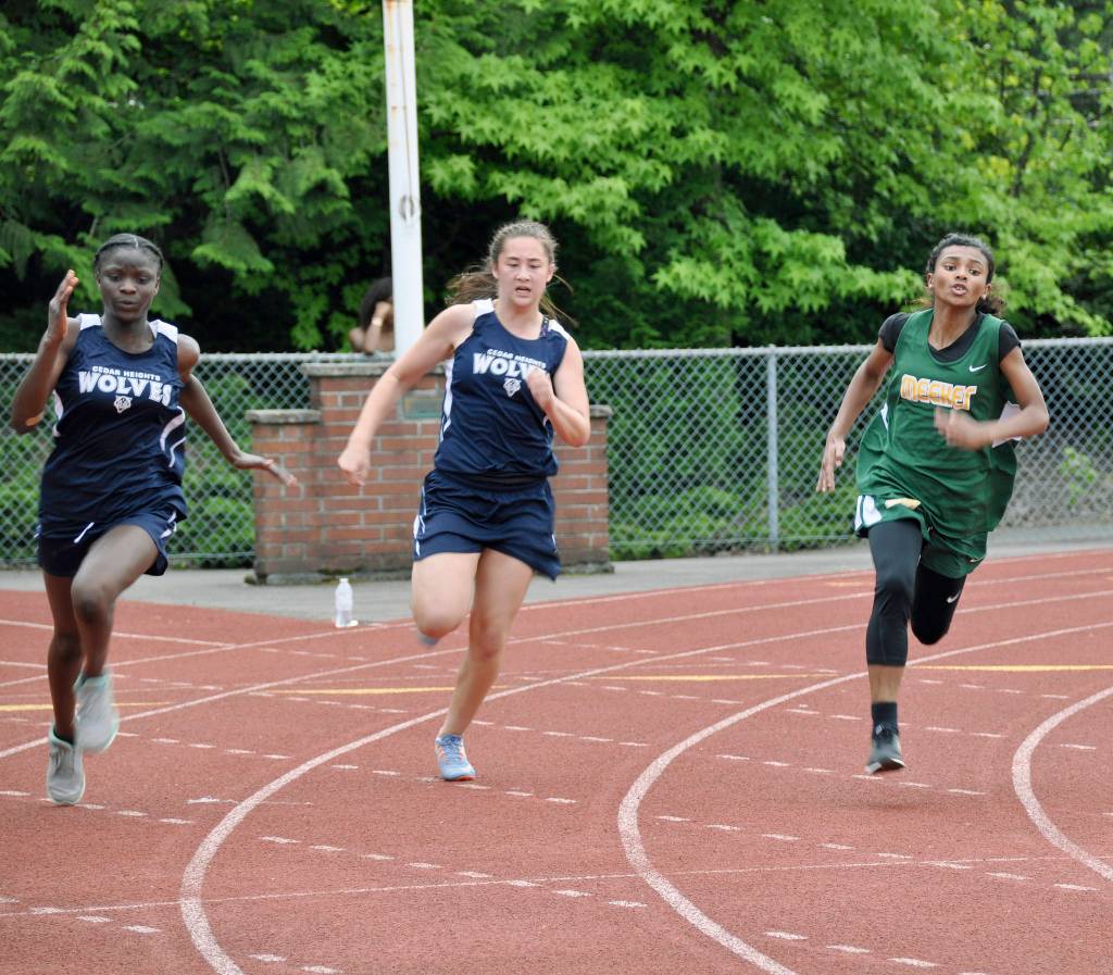 From left, Cedar Heights&rsquo; Kadija Konneh and Morgan Fong and Meeker&rsquo;s Mariana Reams round the curve in the girls 200 meters. HEIDI SANDERS, Kent Reporter
