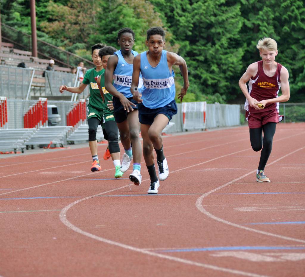A runner from Mill Creek takes off with the baton durign the boys 4x200 meter relay. HEIDI SANDERS, Kent Reporter