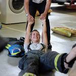 Tyanna Cole, left, laughs as the Explorers help her take her boots off. LEAH ABRAHAM, The Reporter