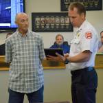 Puget Sound Fire Battalion Chief Tim Martinsen presents a lifesaving award to Jack Scheel on Wednesday at Fire Station 78 in Covington. Courtesy Photo/Puget Sound Fire