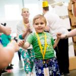 Five-year-old Penny Armstrong of Kent is welcomed by cheering Amazon associates at the fulfillment center. Courtesy Photo/Amazon