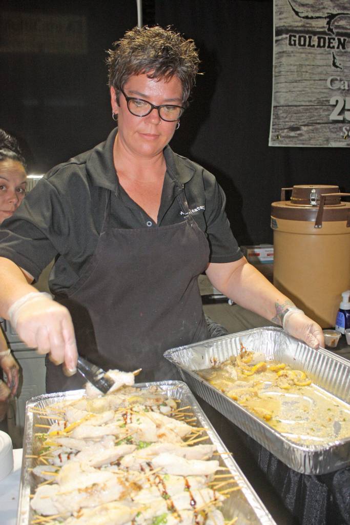 Kari Dixon, of Alki Bakery Cafe and Catering, prepares food for customers to taste. MARK KLAAS, Kent Reporter