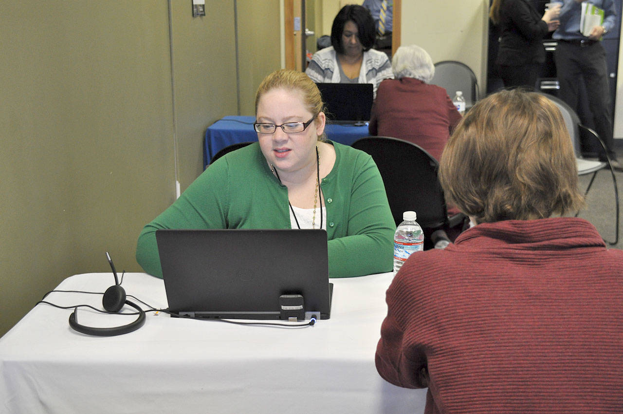Elizabeth Winders helps a client at the health care enrollment center in Federal Way. The center opened on Wednesday to help South King County residents with their health insurance enrollment questions. HEIDI SANDERS, the Mirror