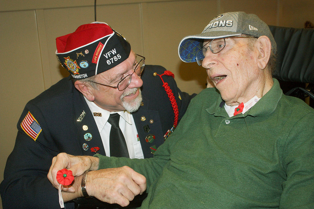 Craig Daughtery, Post commander for Kent Meridian VFW 6785, talks to World War II veteran Larry Clements, 96, during the Posts visit to the Arbor Village Memory Care facility last Friday. Clements, a longtime Kent area resident, served on the battleship USS Colorado in the South Pacific. The Navy years (1939-45) made a man out of a Nebraska farm boy, the most memorable and influential time of his life. MARK KLAAS, Reporter