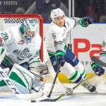 The Thunderbirds Jarret Tyszka, middle, and Nolan Volcan, right, reach to push the puck away from goalie Matt Berlin during WHL play against Spokane on Friday night. COURTESY PHOTO, Brian Liesse, T-Birds