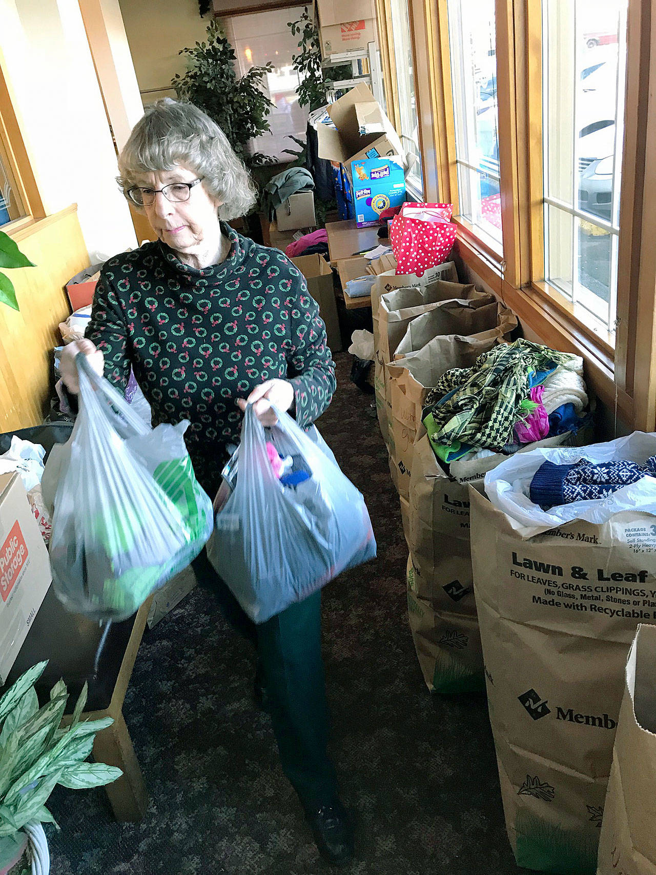 Barbara DeChene of Willows Place helps organize the mass collection of clothing and items during the luncheon. MARK KLAAS, Kent Reporter
