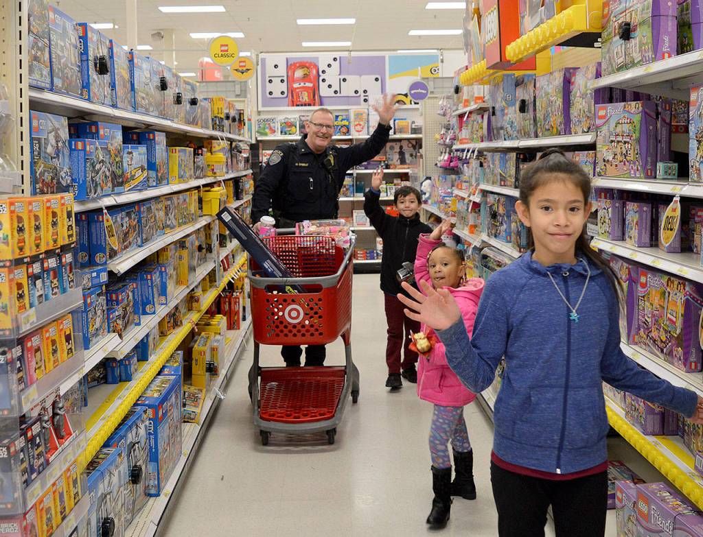 A Kent Police officer helps children find holiday gifts at Target. COURTESY PHOTO, Kent Police
