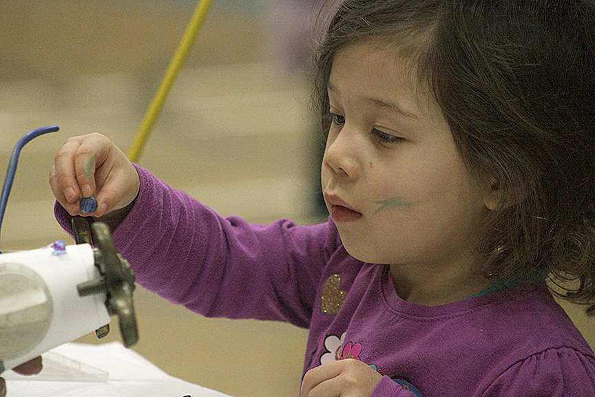 Mark McMillens 3-year-old daughter, Fern, applies some finishing touches to the robot they built from scrap during Kent Kids Arts Day. MARK KLAAS, Kent Reporter
