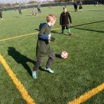 Kids take to the new synthetic soccer field surface during the grand reopening of Hogan Park at Russell Road on Saturday. The baseball/softball outfield can serve as a pitch for soccer and a field for flag football, lacrosse and rugby. MARK KLAAS, Kent Reporter
